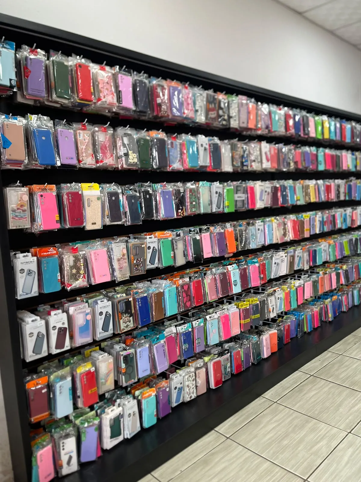 Salão da FS Celulares com parede de capinhas e gôndolas